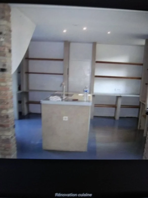 Cuisine d'atelier · Amiens — Îlot en béton, murs de brique conservés, étagères en bois clair : le style loft dans une maison picarde.