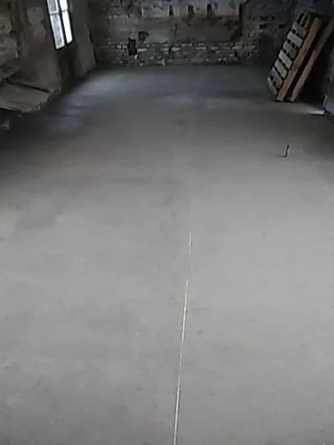 Dalle béton coulée — Une dalle lissée dans une pièce en rénovation, prête pour le carrelage.