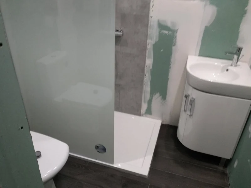 Douche à l'italienne carrelée avec paroi vitrée, éclairage doux