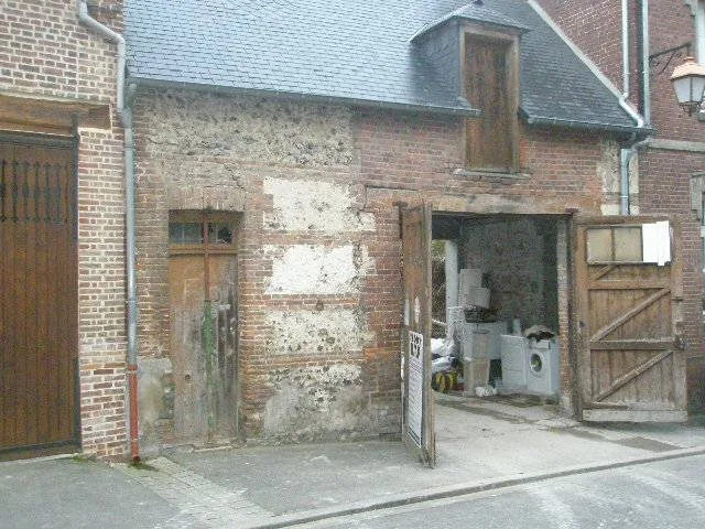 Rejointoiement · Abbeville — Une façade ancienne en brique et silex avant reprise des joints à la chaux.