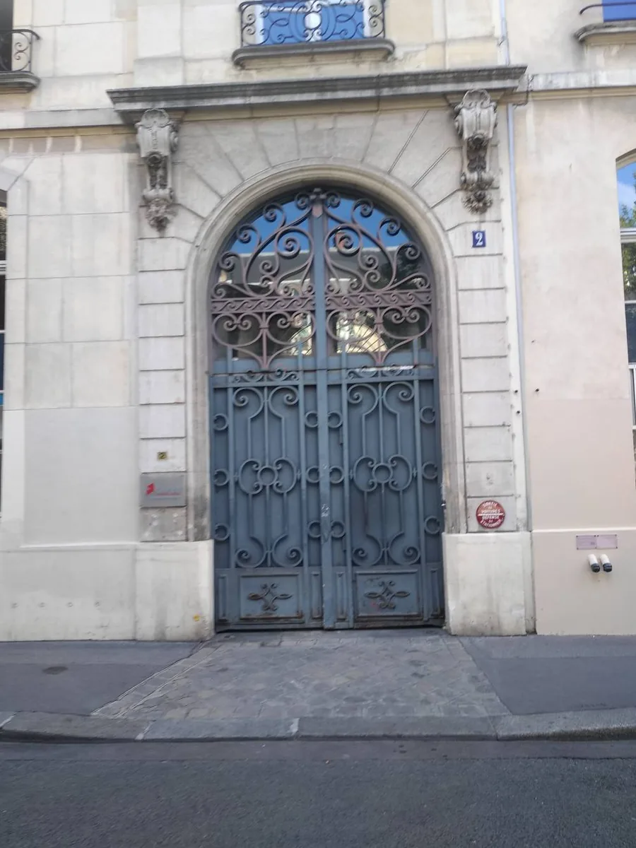 Porte cochère restaurée — Menuiserie ancienne décapée et repeinte en bleu profond, ferronnerie conservée.
