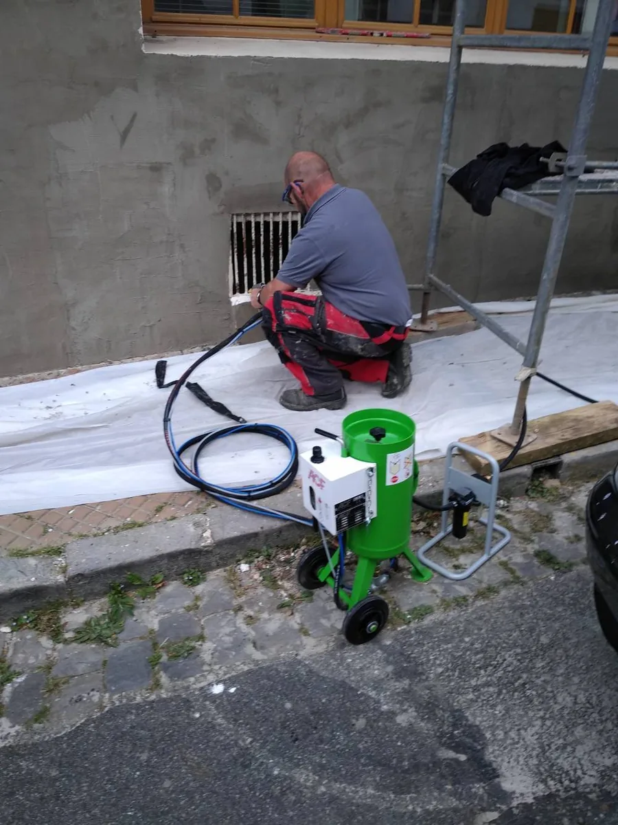 Rejointoiement d'une façade de brique en cours, joints dégarnis