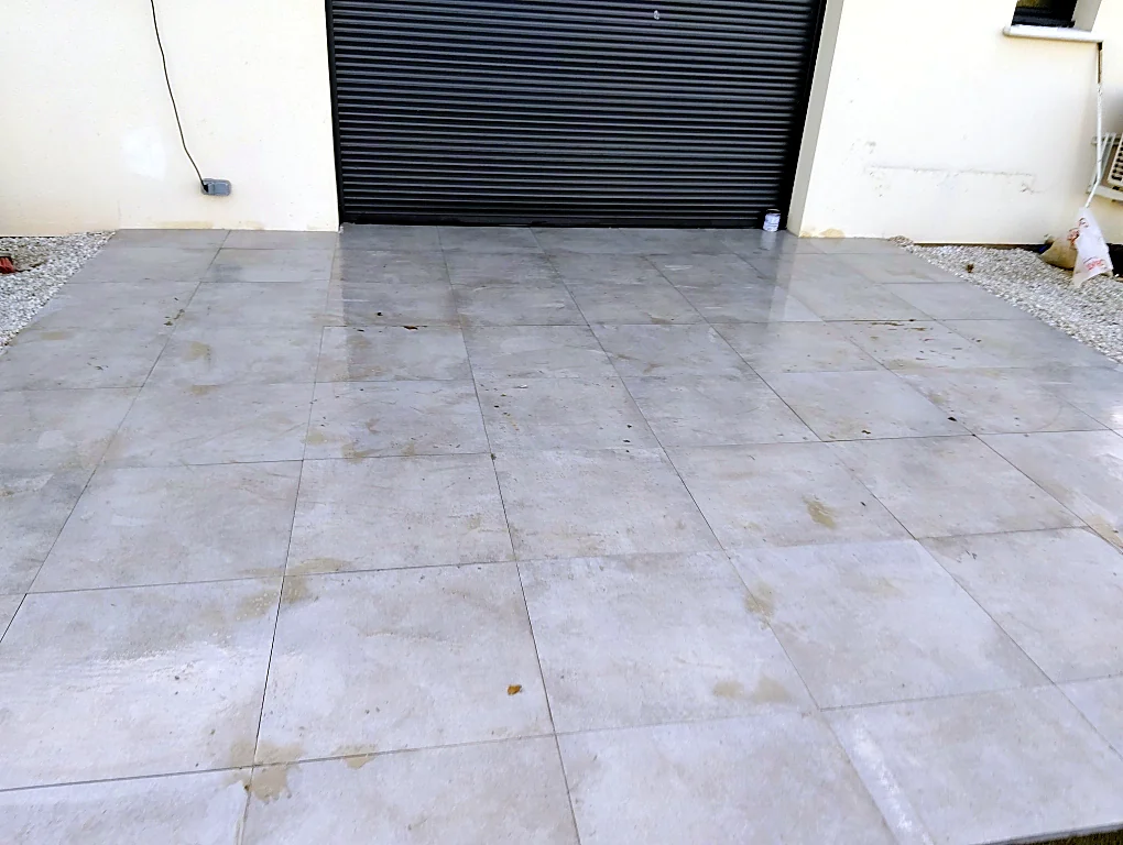 Après : terrasse carrelée grand format de plain-pied avec le garage